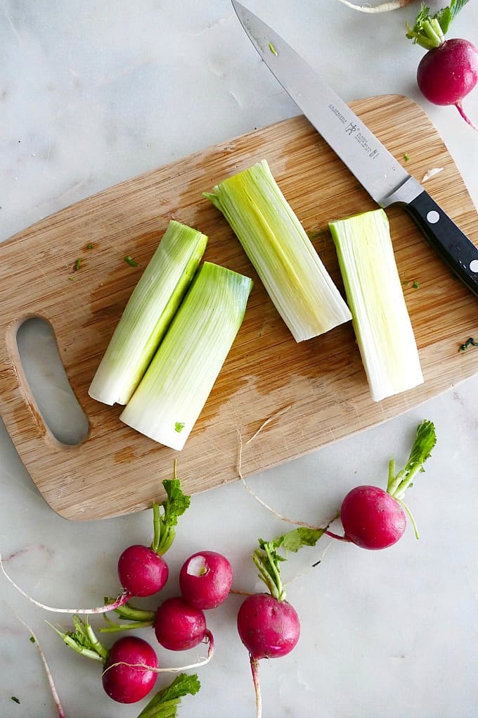 Leeks and radishes on a cutting board