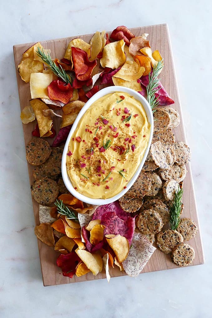 wood board with Butternut Squash Goat Cheese Dip and crackers on a counter