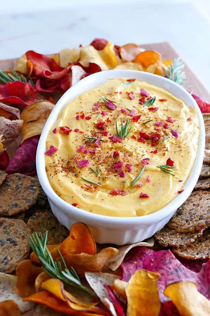 side angle of butternut squash goat cheese dip in the middle of a tray of crackers