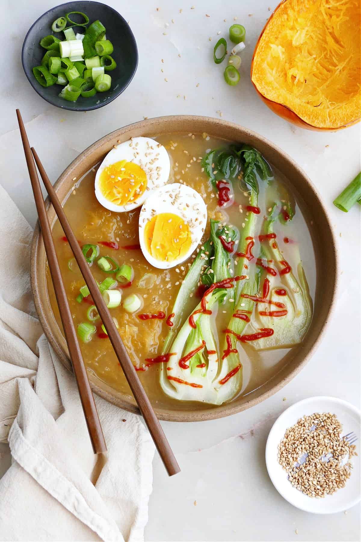 Spaghetti Squash Ramen with a boiled egg and scallions in a bowl with chopsticks