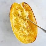 half of a Spaghetti Squash with a fork in it on a counter