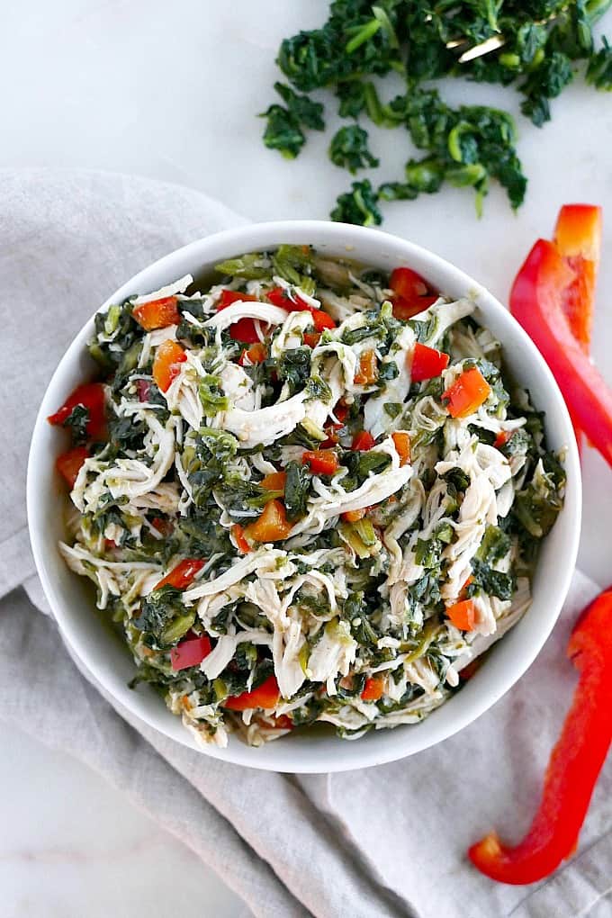 slow cooker Mexican shredded chicken with veggies in a white bowl on top of a napkin