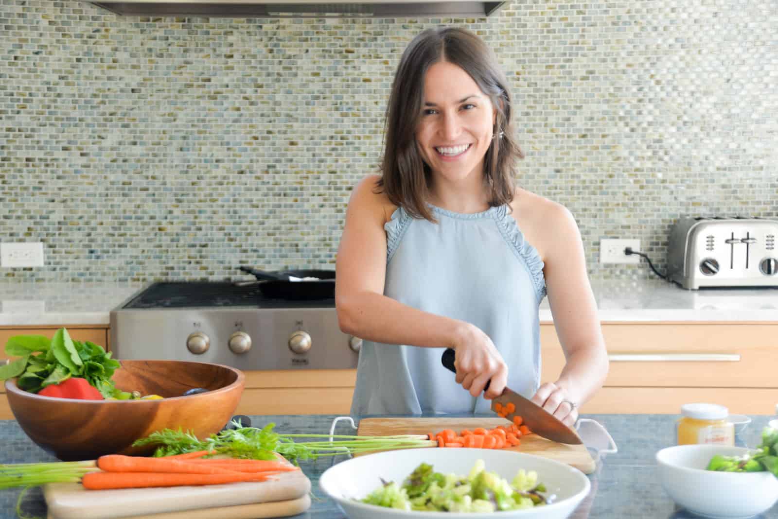 woman slicing carrots in a kitchen