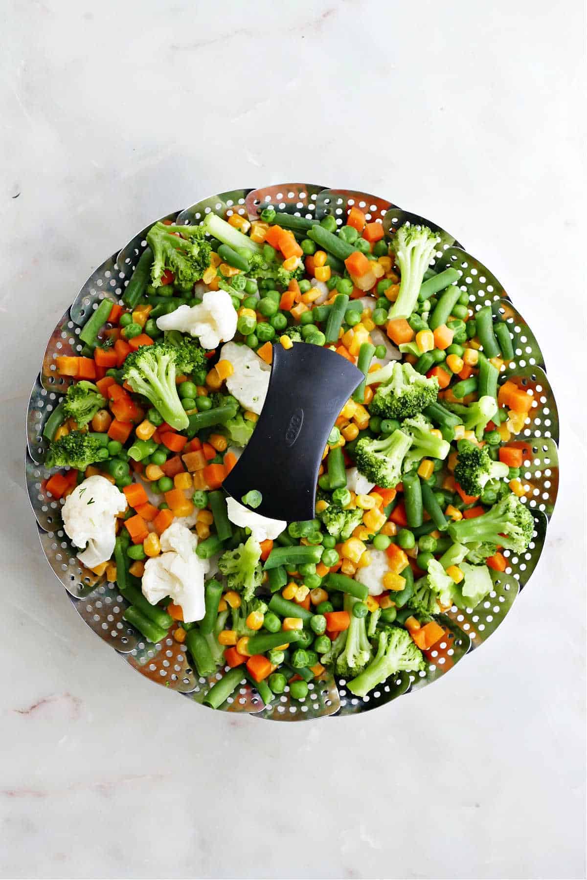 steamed veggies in a steamer basket with text overlay