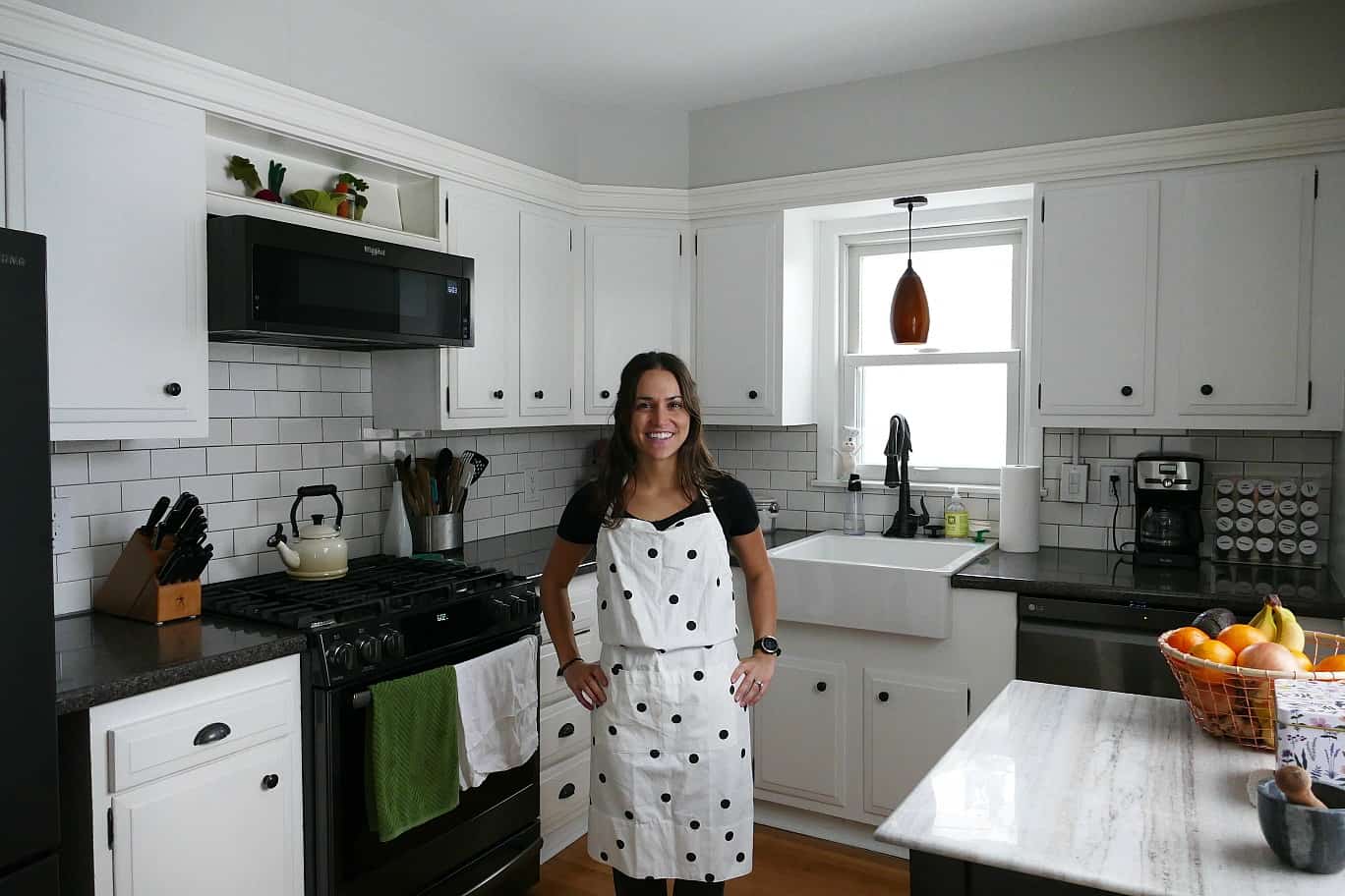 women standing in kitchen in an apron