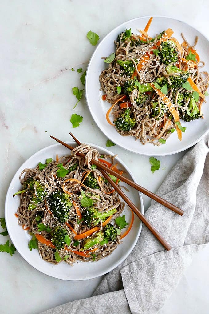 two plates with soba noodles next to each other on a counter