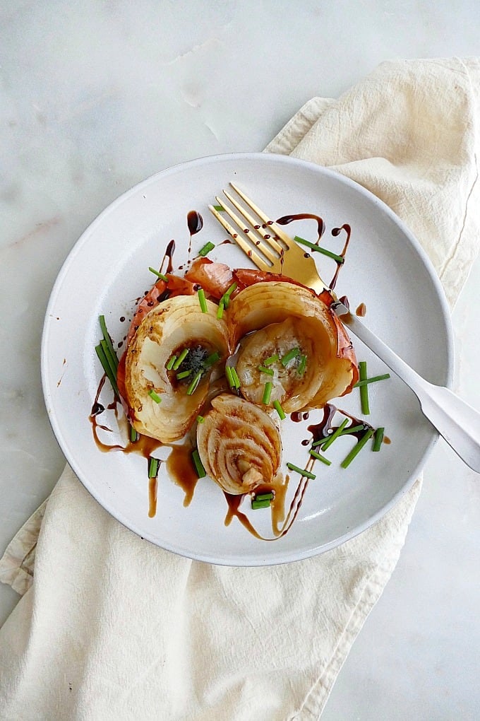 a whole roasted onion with balsamic and chives