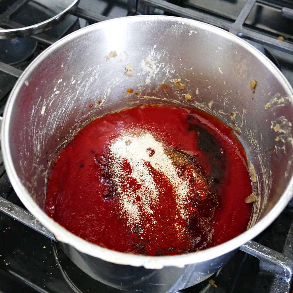homemade barbecue sauce cooking in a saucepan over a stove