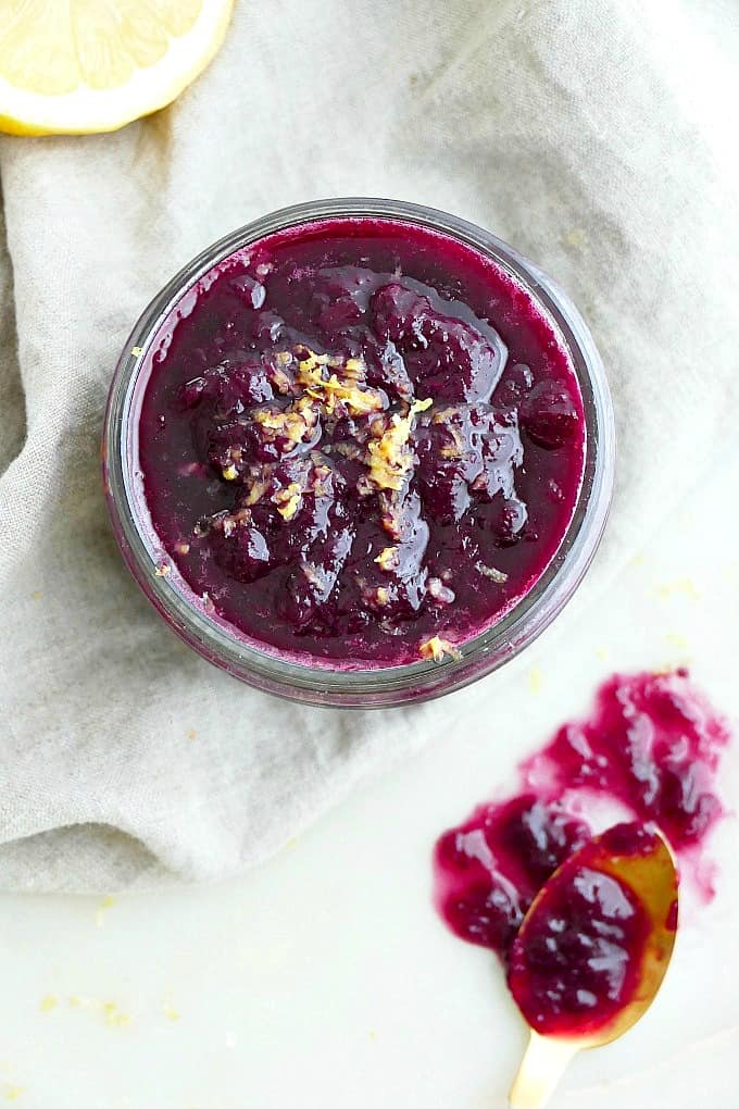 blueberry rhubarb jam with lemon zest in a glass jar on a counter