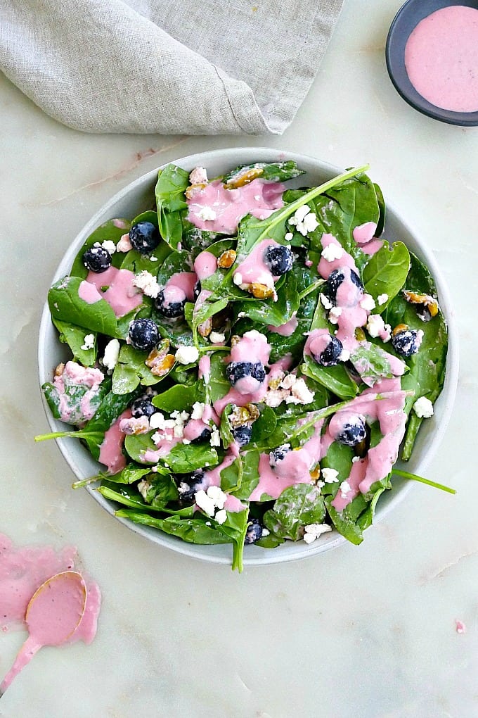 blueberry spinach salad in a serving plate on a counter