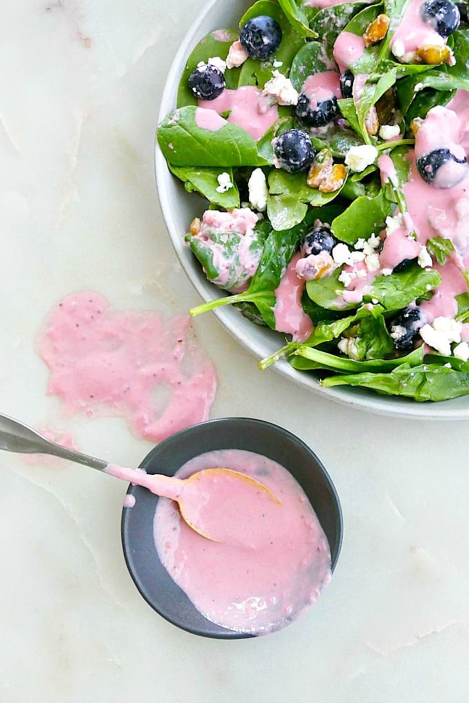 plate of salad next to a small bowl with tahini dressing in it