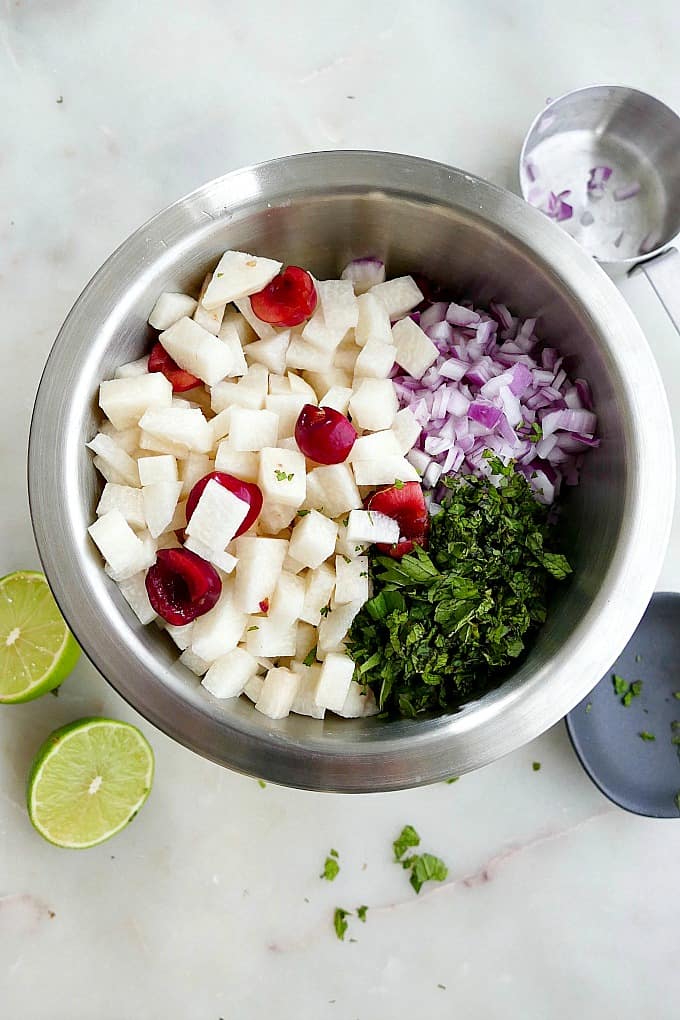 chopped jicama, sliced cherries, chopped fresh mint, and red onion in a large mixing bowl