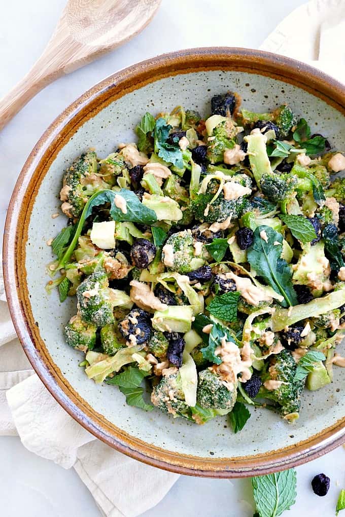 broccoli salad with peanut dressing and dried cranberries in a serving bowl