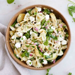 pasta salad with artichokes and mozzarella in a serving bowl on a counter