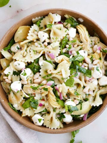 pasta salad with artichokes and mozzarella in a serving bowl on a counter
