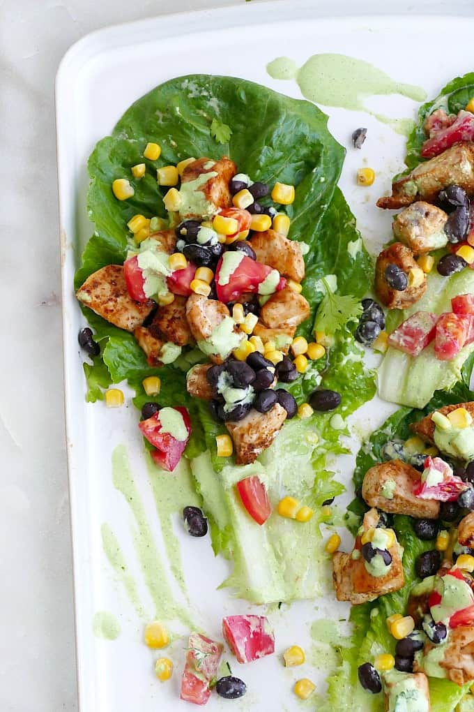 southwest healthy chicken lettuce wraps topped with jalapeno sauce on a platter