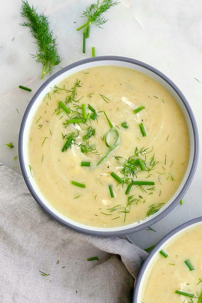 potato garlic scape soup in a gray and white bowl on a counter