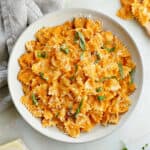 bowtie pasta covered with roasted red pepper sauce in a serving dish