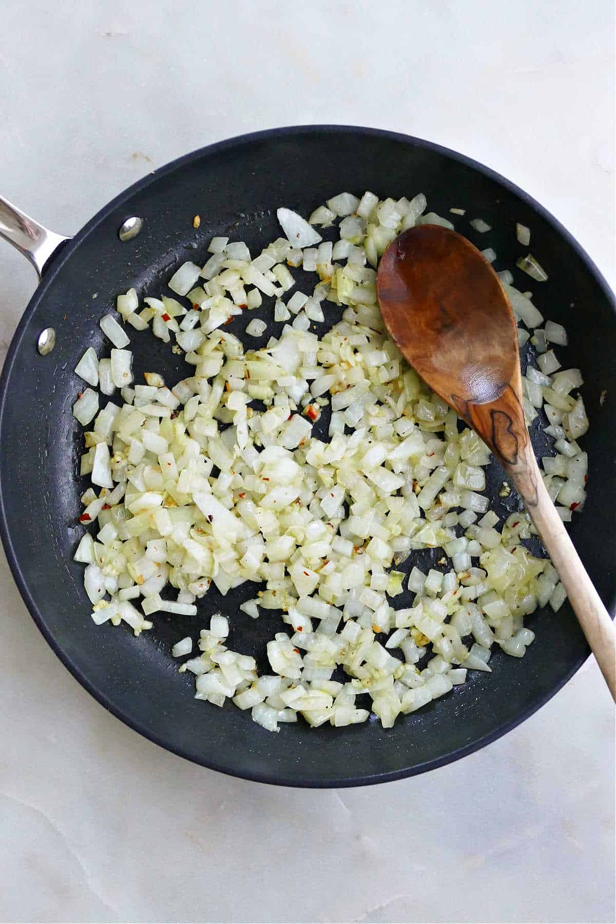 diced onions and garlic cooking in olive oil in a skillet