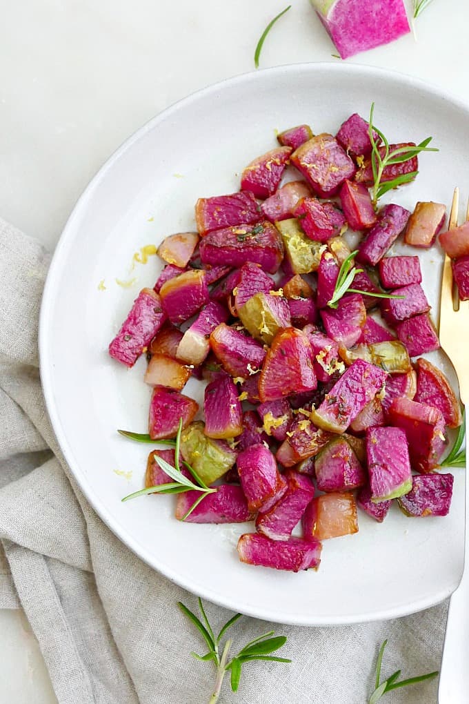 sauteed watermelon radishes with rosemary on a serving plate