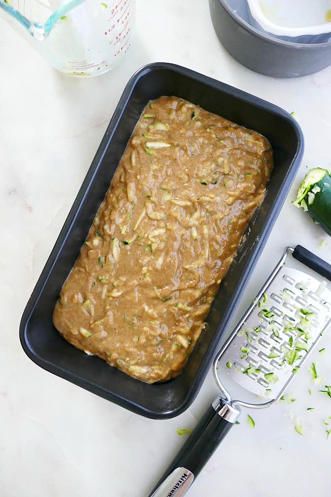 zucchini bread batter in a loaf pan on a counter before going into the oven