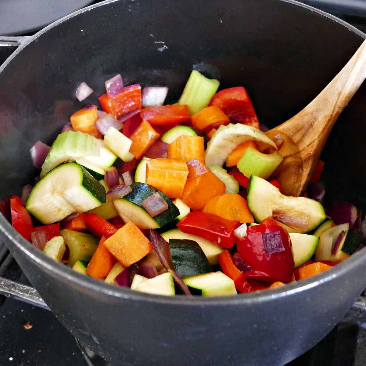 diced vegetables cooking with onions in olive oil in a large pot