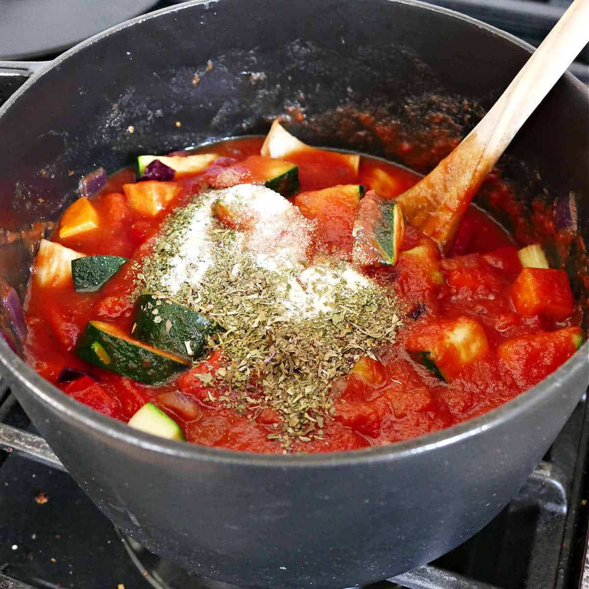 veggie tomato sauce ingredients and spices cooking in a large pot
