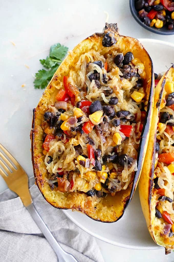 spaghetti squash burrito bowl with beans, peppers, and corn on a serving plate