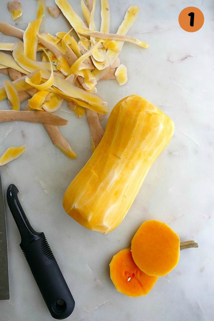 peeled butternut squash with peelings and stem on a countertop