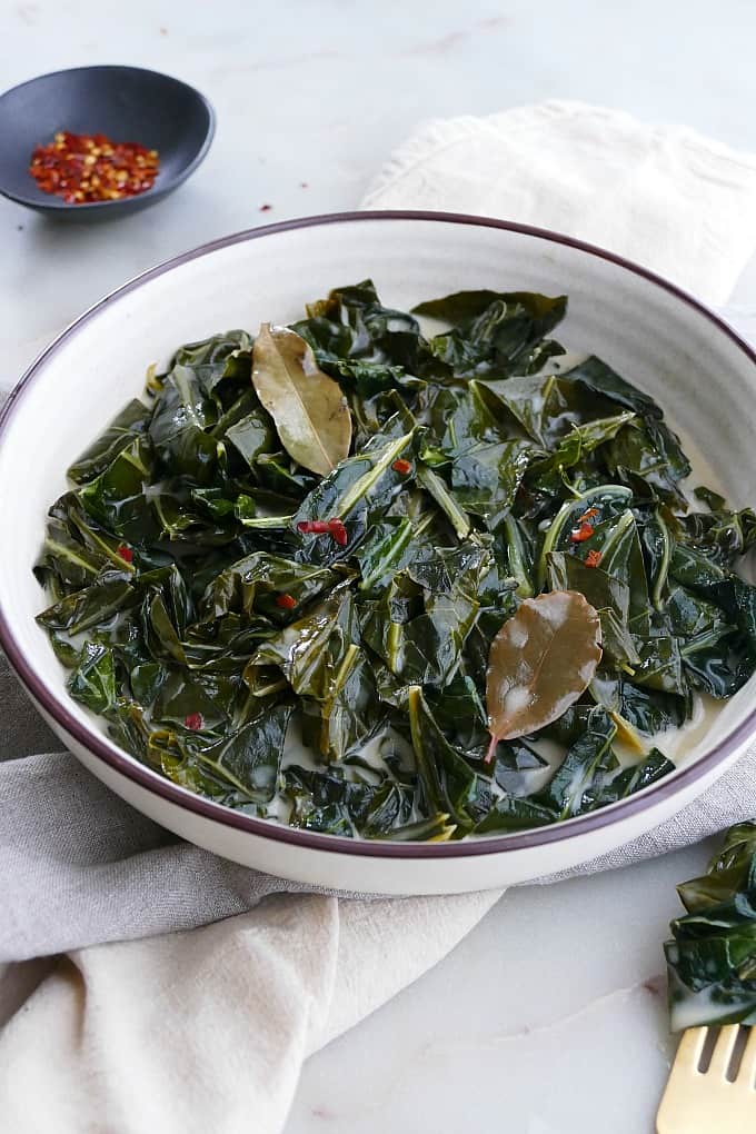 angled shot of vegan collard greens in a white bowl 