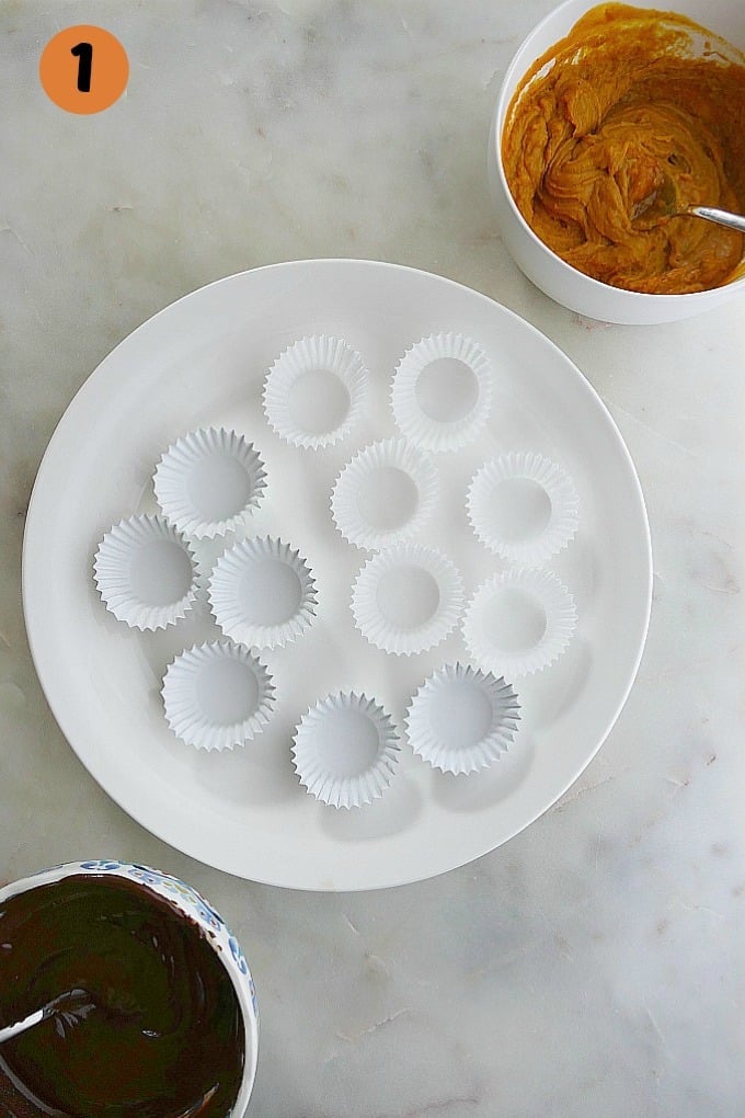 white plate with empty mini cupcake liners on it