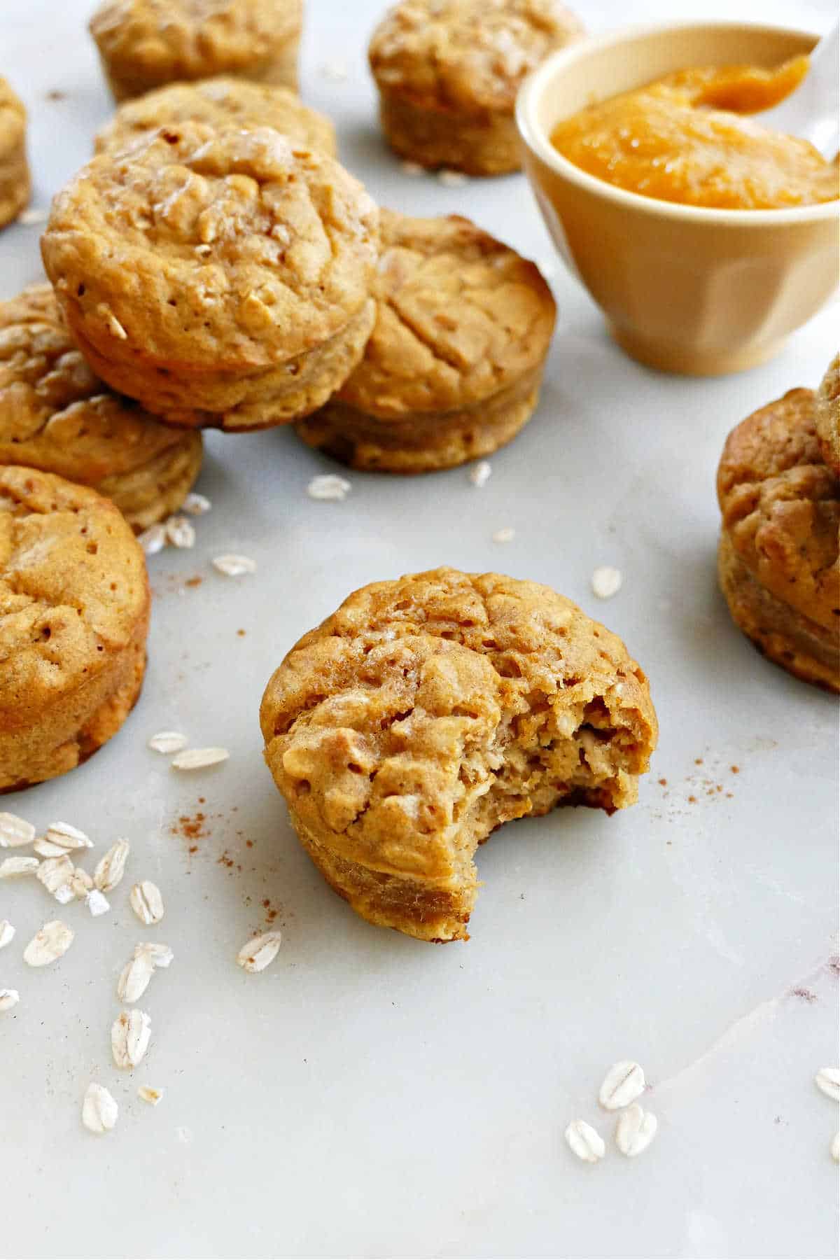 6 butternut squash muffins sprinkled with oats on a serving plate on a counter