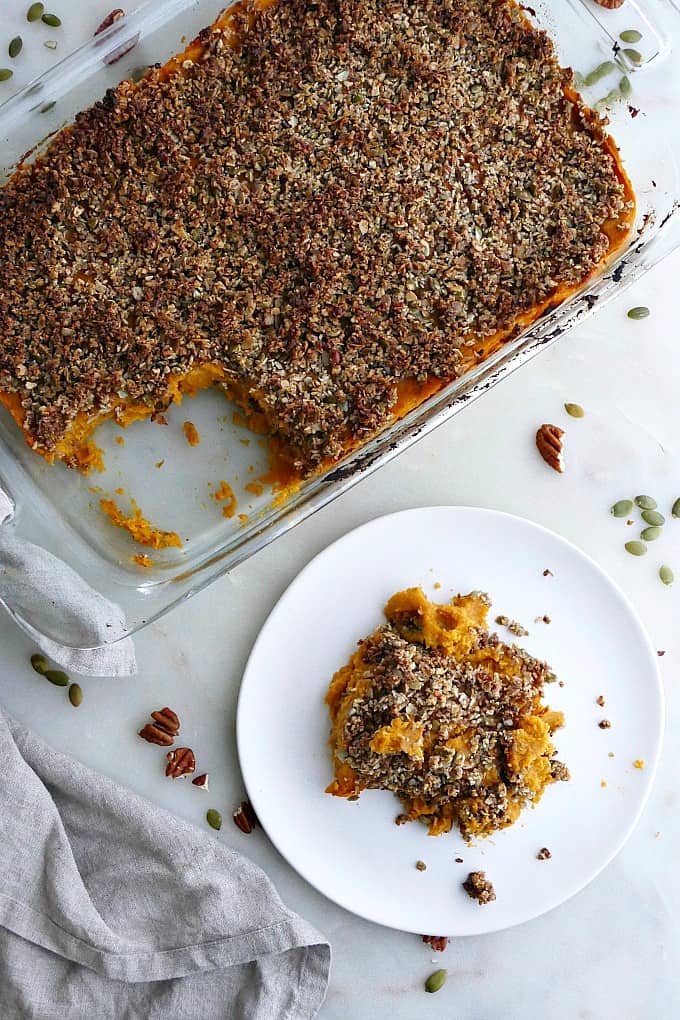 dish with gluten free sweet potato casserole next to a plate with a serving of it