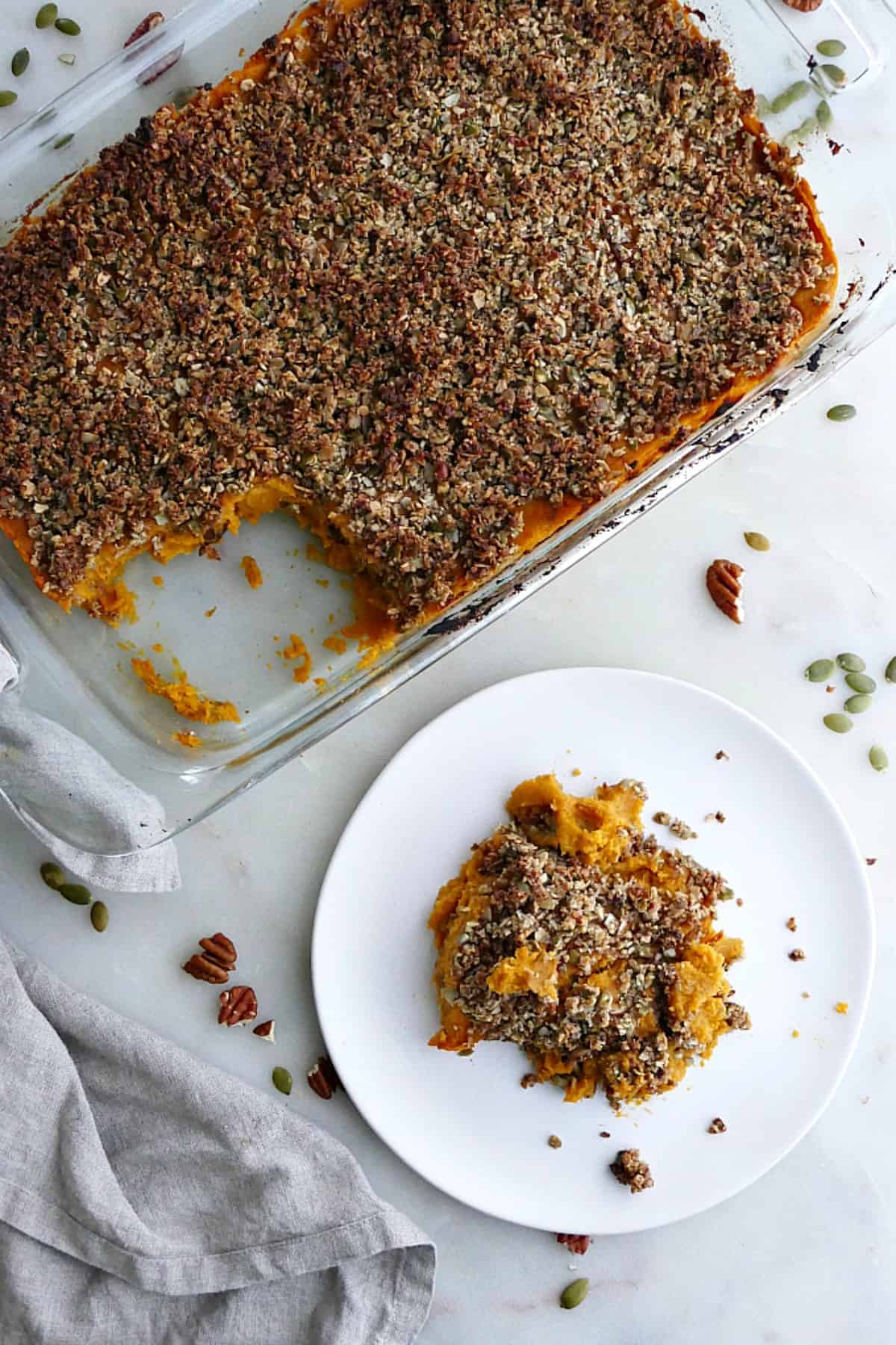 Dish with gluten free sweet potato casserole next to a plate with a serving of it.