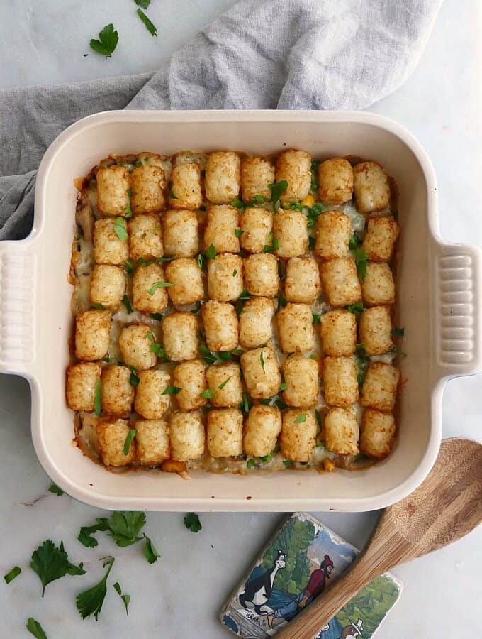 healthy tater tot casserole in a baking dish on a gray napkin on countertop