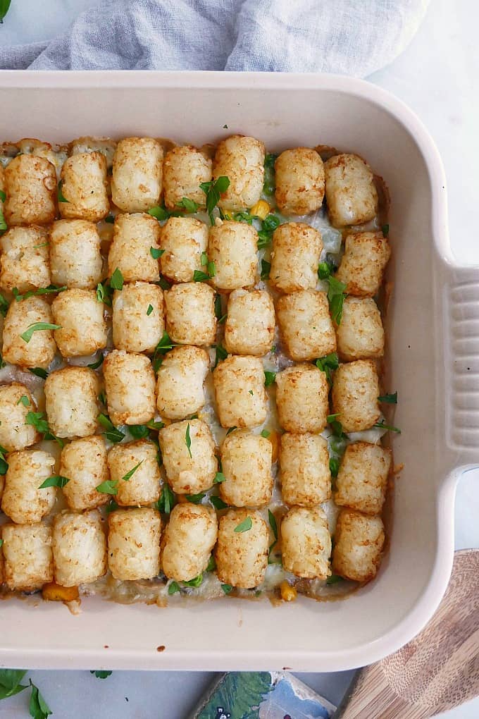 close up of healthy tater tot casserole in a ceramic baking dish