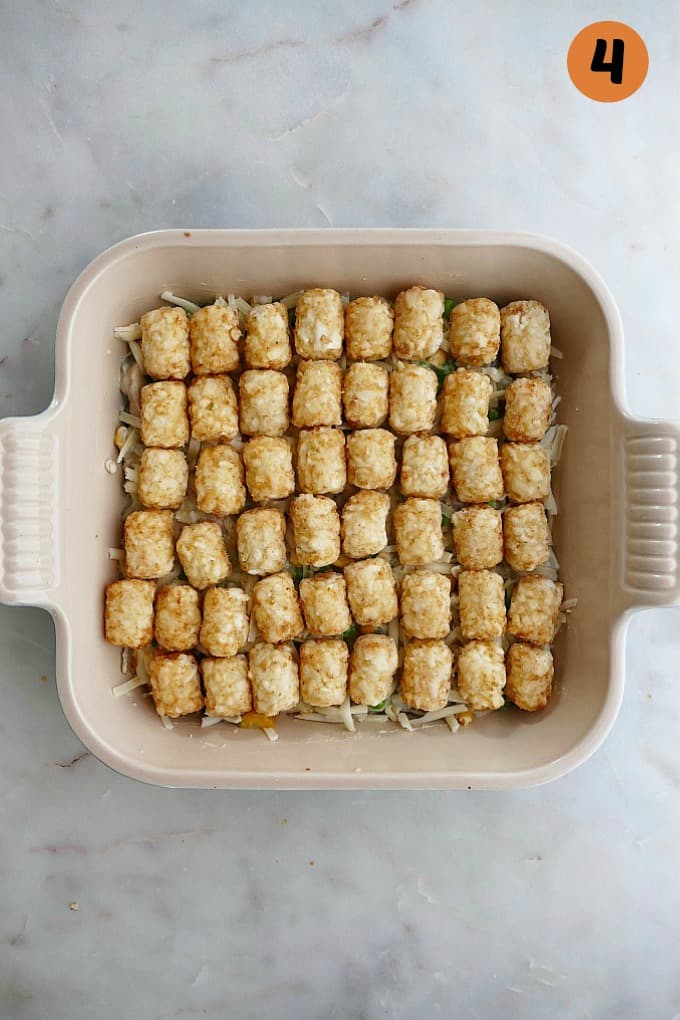 tater tot casserole before it goes in the oven in a baking dish on countertop