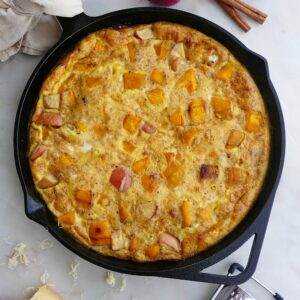 apple pumpkin frittata with gouda in a black skillet on a countertop
