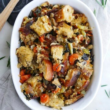vegetable stuffing in a white oval baking dish on a counter
