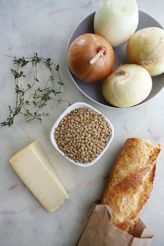ingredients for french onion soup with lentils on a white countertop