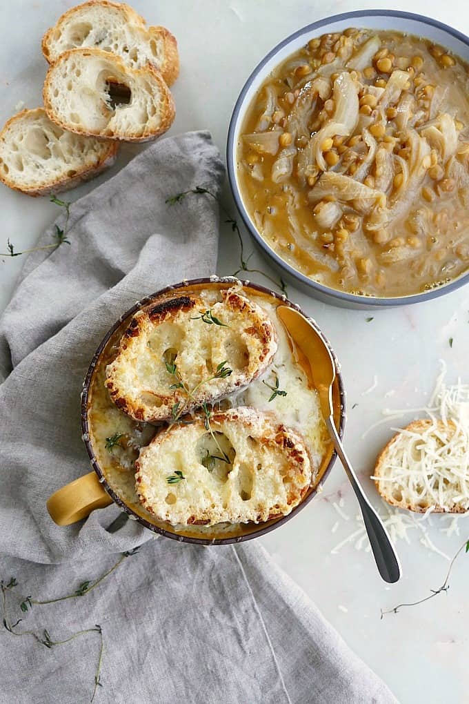 vegetarian french onion soup with lentils in a small bowl next to a larger bowl