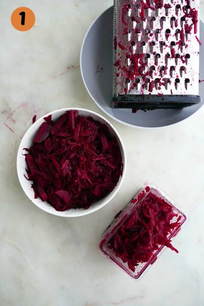 grated beets in a white bowl with a grater next to it