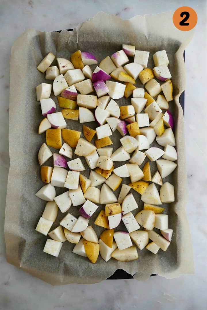 baking sheet lined with parchment paper with diced turnips and pears