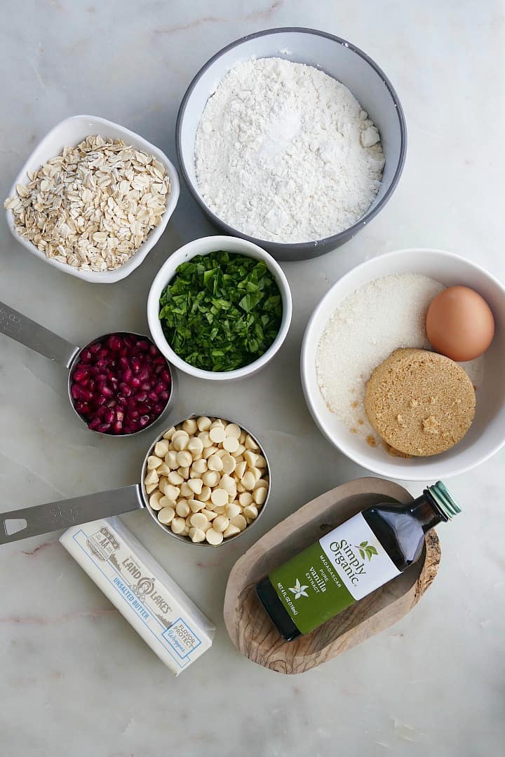 ingredients for white chocolate chip spinach cookies in bowls on a white counter