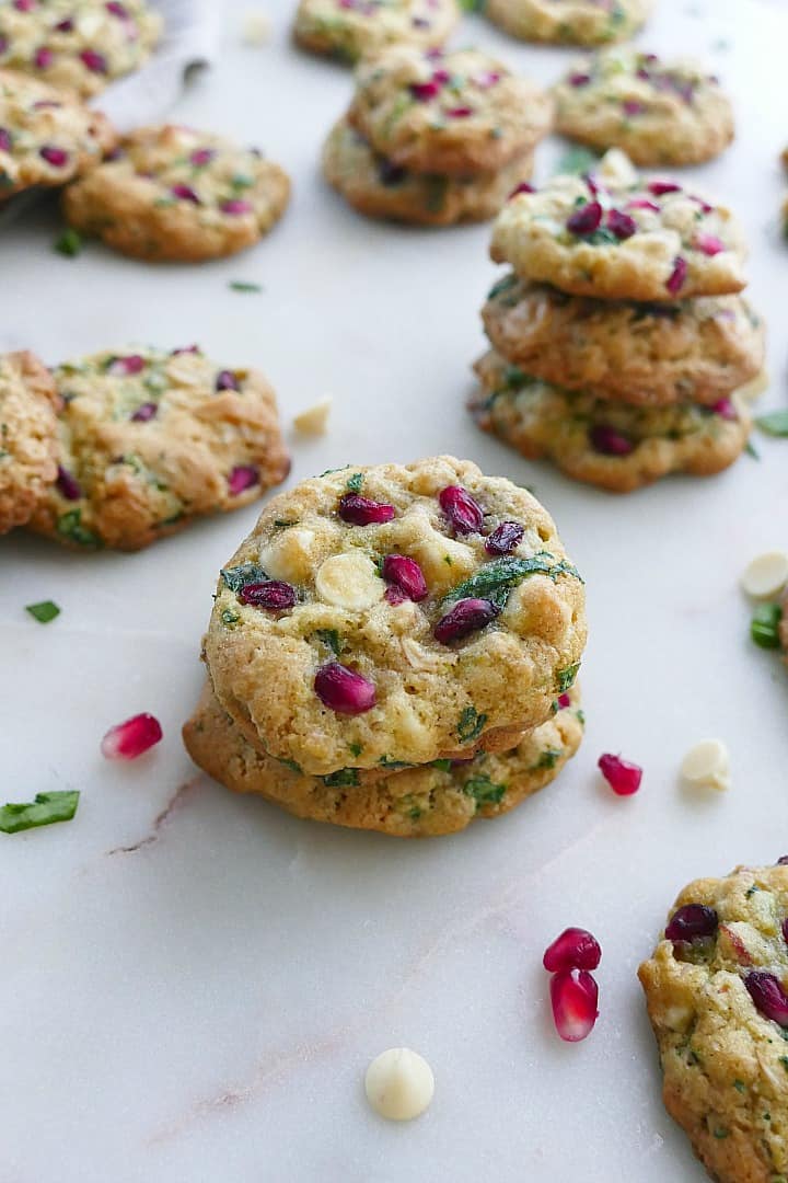 two spinach cookies stacked on top of each other with cookies behind them