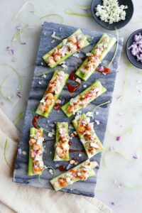 8 buffalo chickpea salad stuffed celery sticks next to small bowls