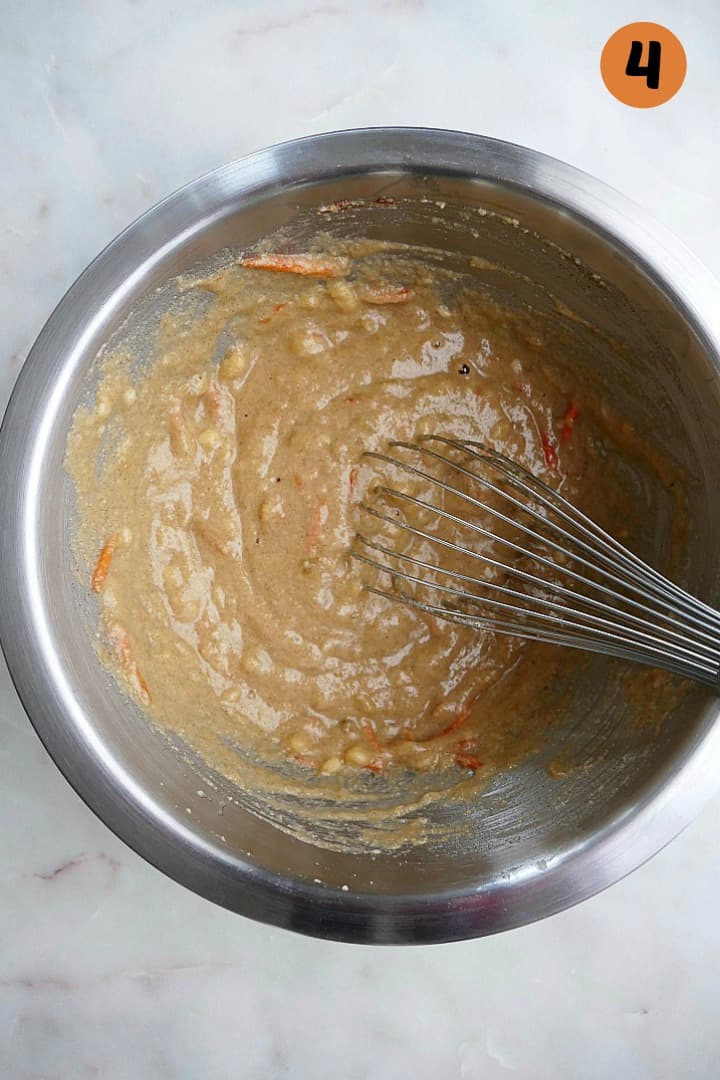 wet and dry ingredients for carrot banana bread whisked together in a bowl