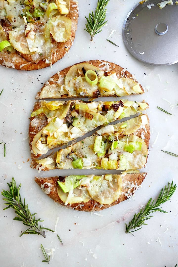 one potato leek pizza on pita sliced into 4 pieces on a white counter