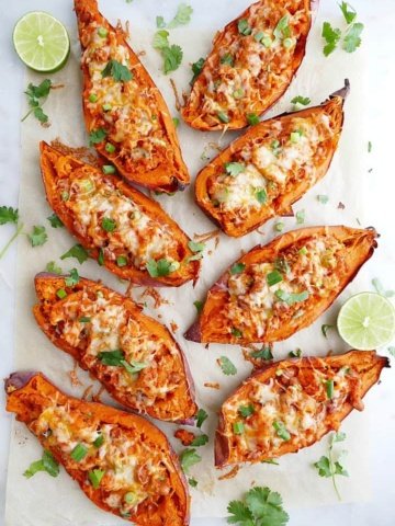 8 sweet potato skins on a white counter with cilantro and limes