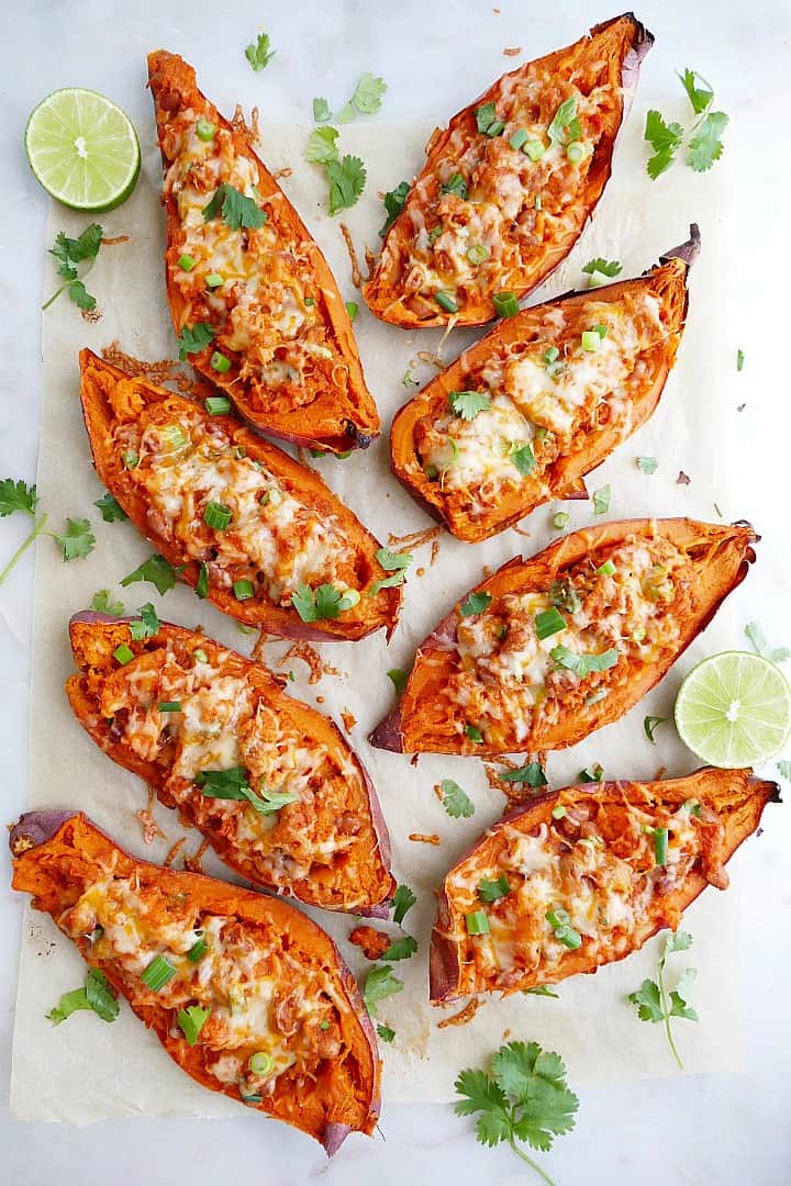 8 sweet potato skins on a white counter with cilantro and limes